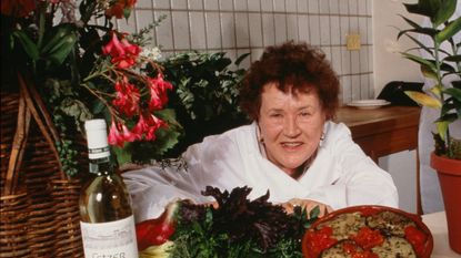 Julia child in kitchen with food and wine