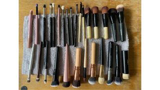 Two rows of vertical makeup brushes laying on a towel