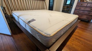 Saatva memory foam hybrid mattress on a bed frame in tester's bedroom