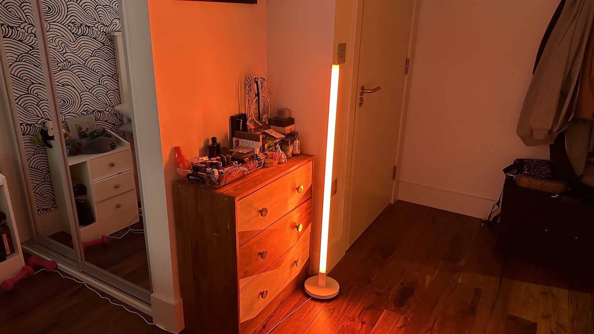 Wiz Luminaire Pole Floor Light orange brillant dans un coin salon.