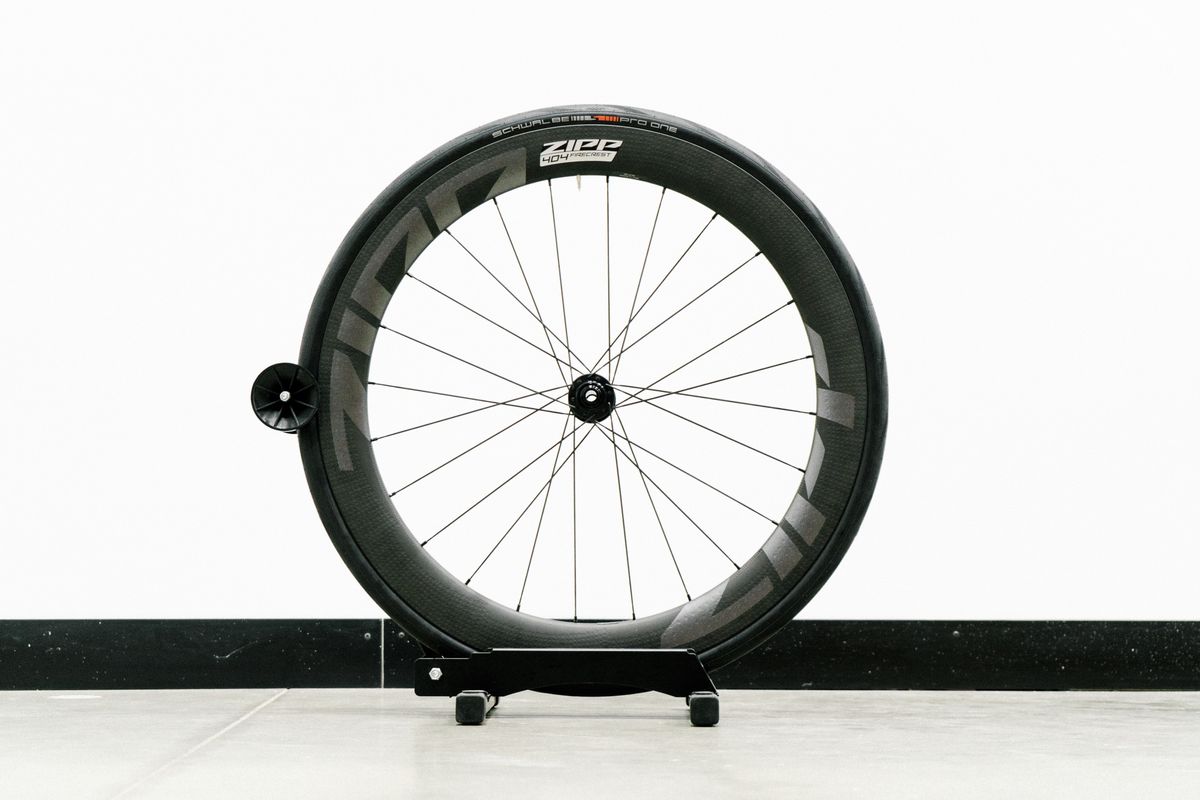 An aero road wheel stands against a white wall