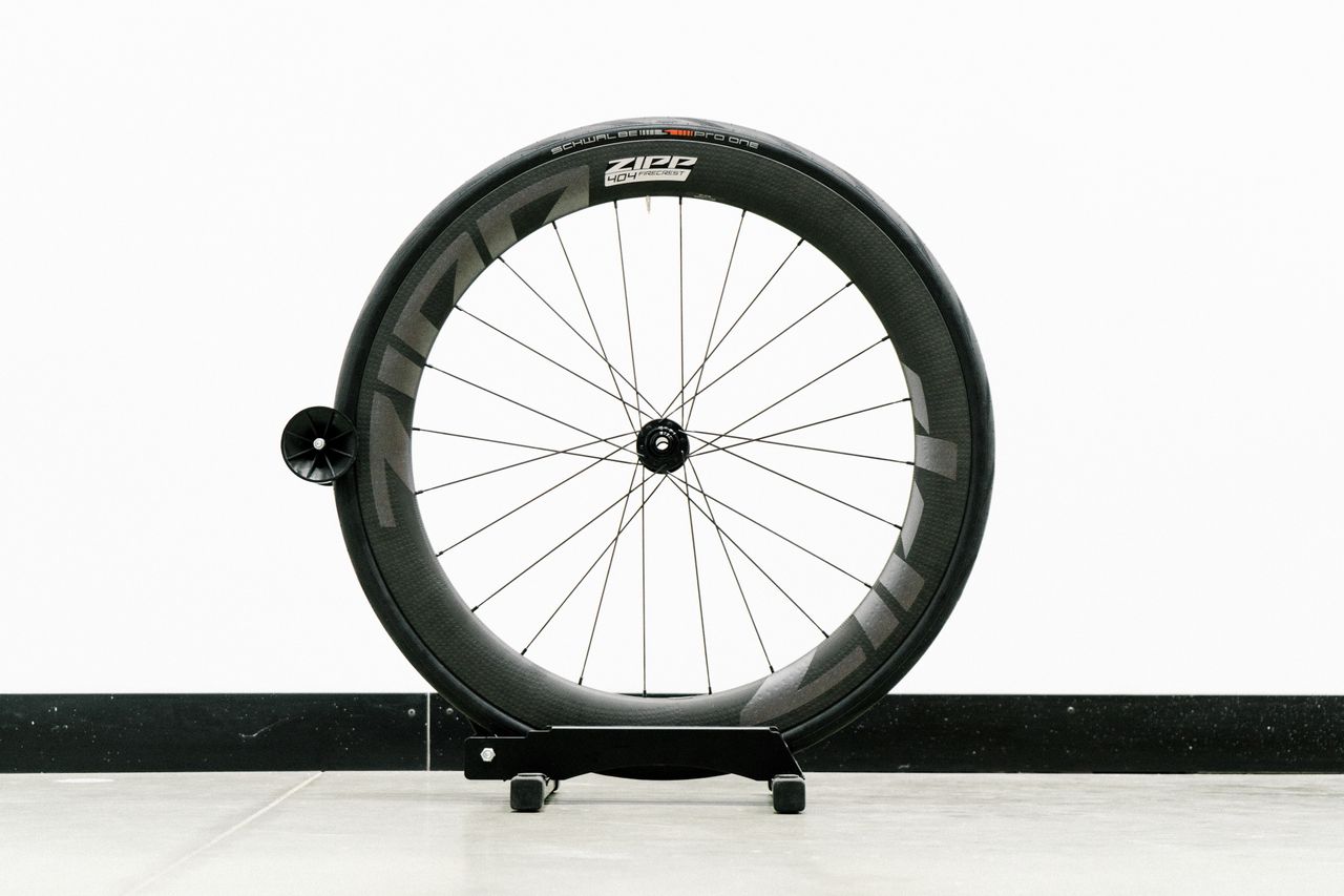 An aero road wheel stands against a white wall