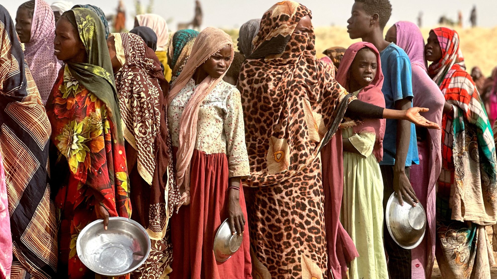Women and girls from Sudan queue up at refugee camp