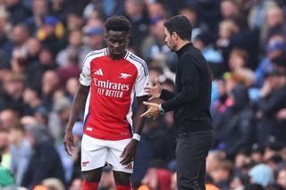 MANCHESTER, ENGLAND - SEPTEMBER 22: Bukayo Saka of Arsenal is instructed by Mikel Arteta manager / head coach of Arsenal during the Premier League match between Manchester City FC and Arsenal FC at Etihad Stadium on September 22, 2024 in Manchester, England. (Photo by Robbie Jay Barratt - AMA/Getty Images)