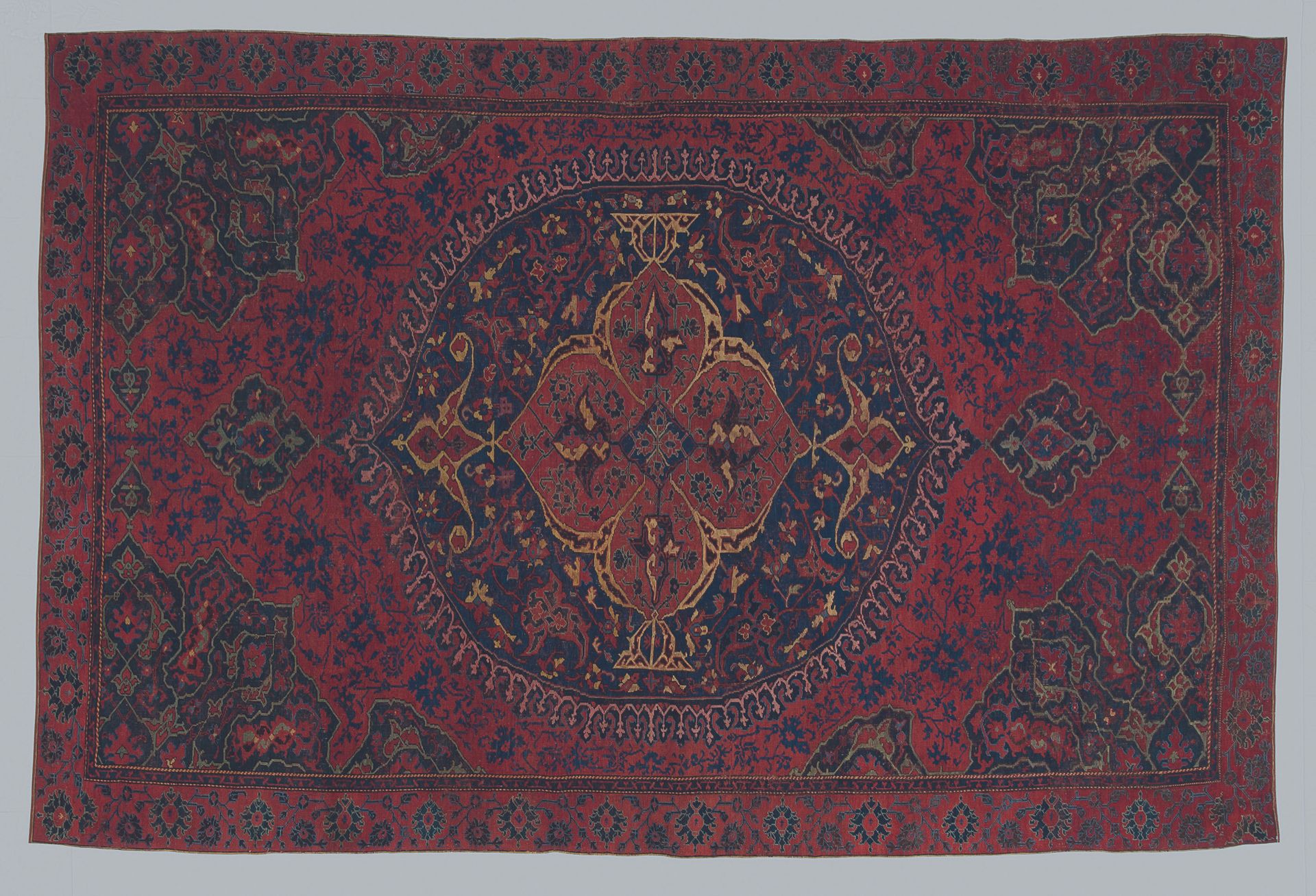 A red Turkish rug on a white background