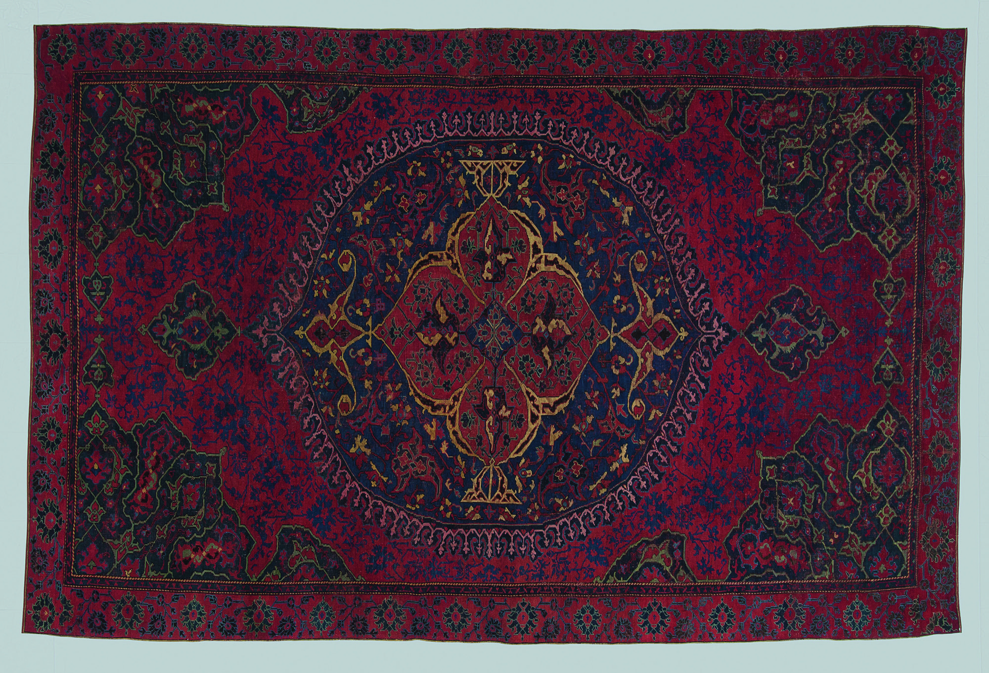 A red Turkish rug on a white background