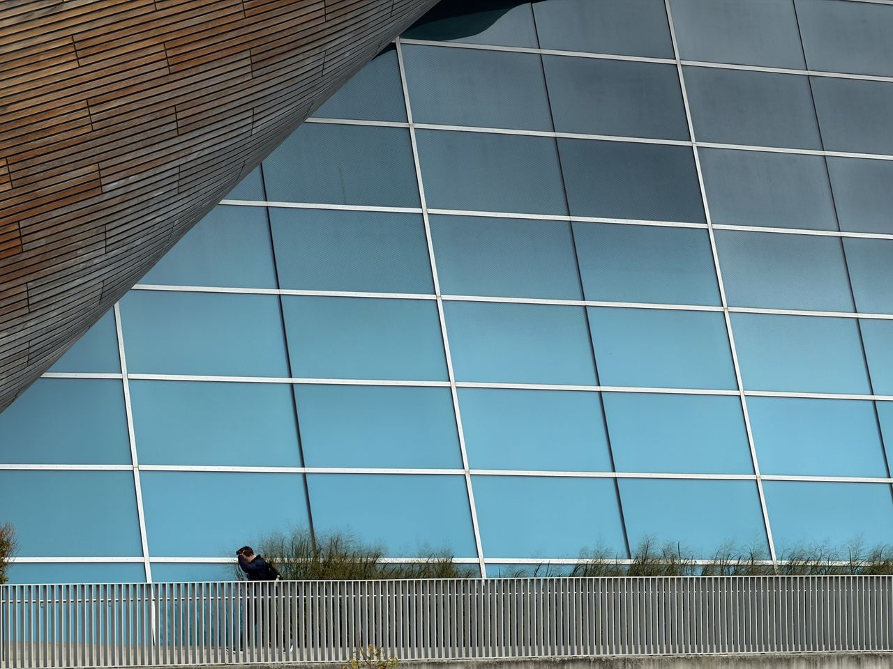 Sample photo from iPhone Pro showing large window with a man walking in front