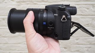 Sony RX10 IV camera in person's hand with zoom extended