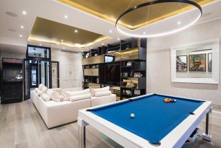 luxury lighting idea in a man cave style living room with pool table and large sectional sofa