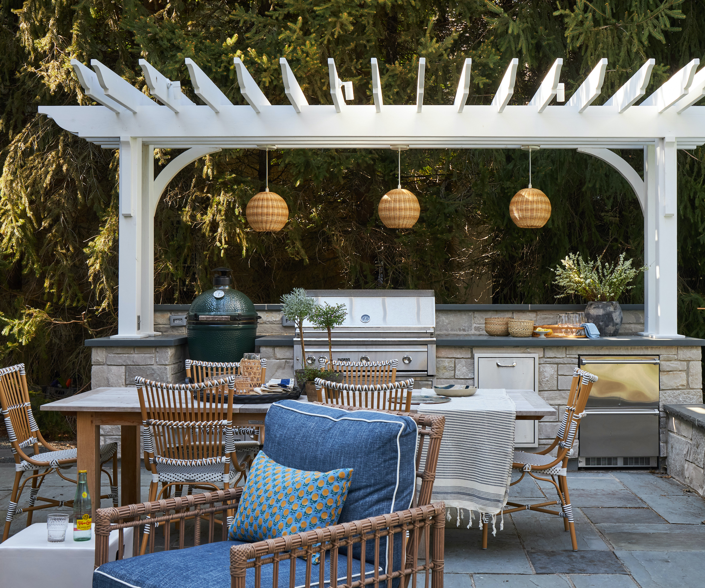 outdoor kitchen with pergola roof and dining furniture