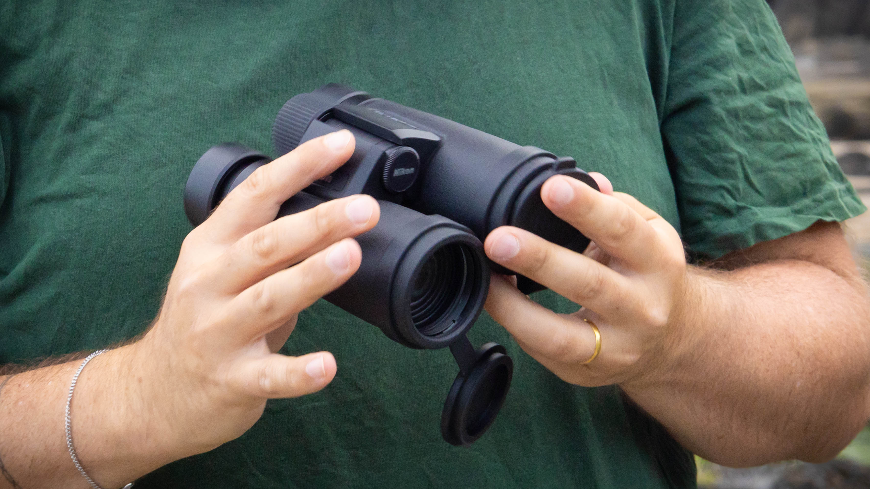 A close-up of a person holding the Nikon Monarch M7 8x42 binoculars.