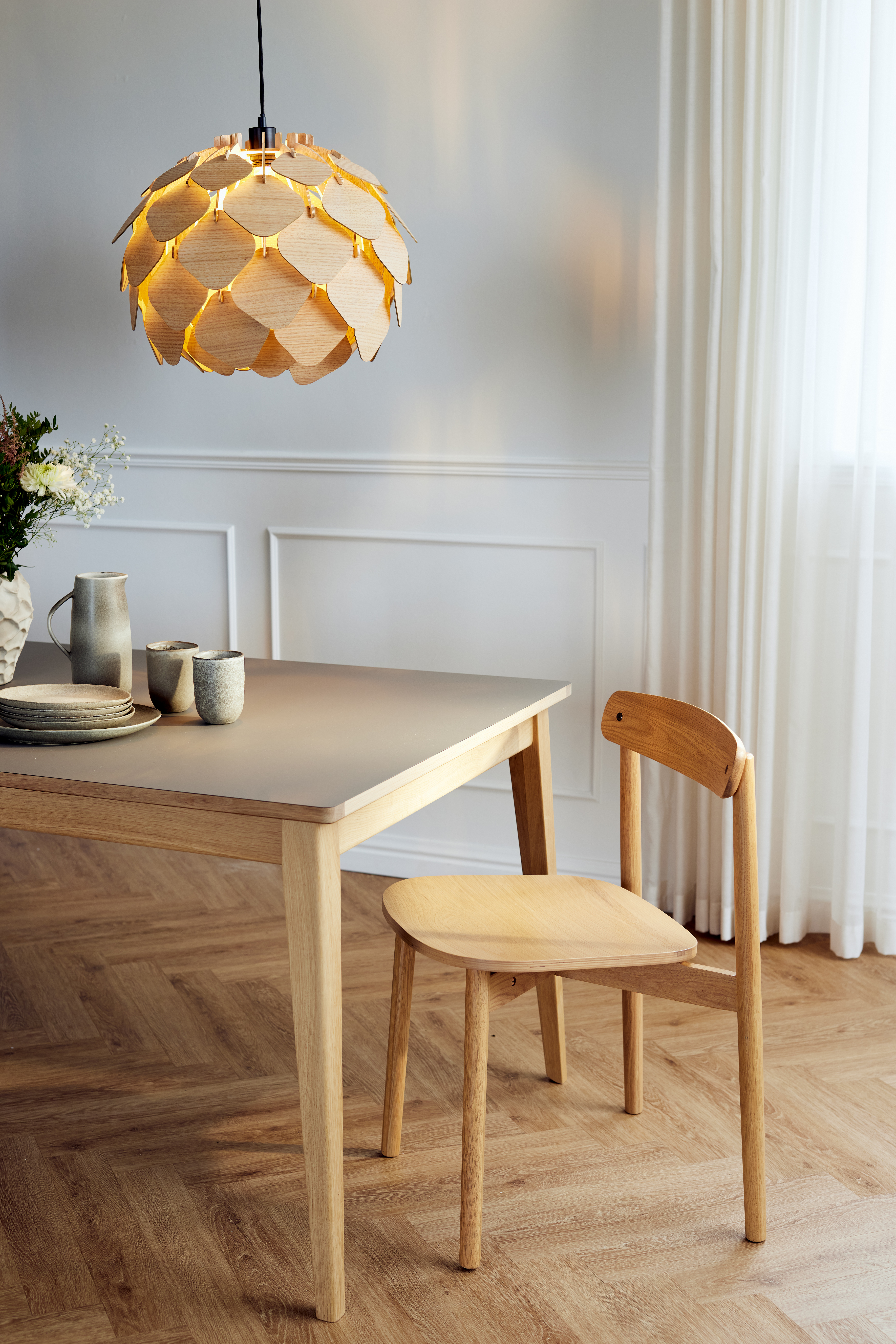 scandi wooden dining table and chair on a parquet floor