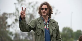 Joaquin Phoenix throwing up a peace sign in Inherent Vice