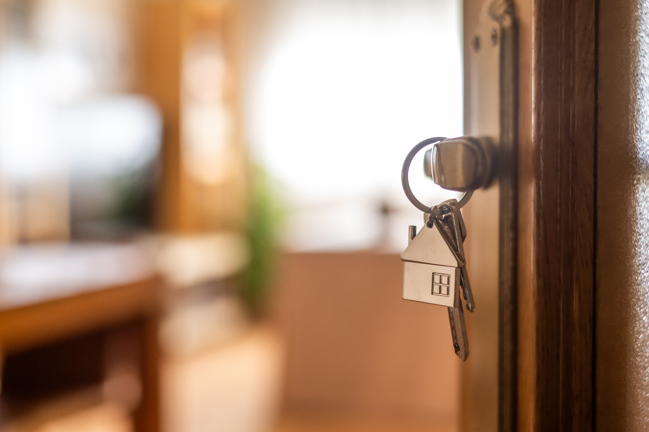 House-shaped keys are hanging from the door knob of a new home