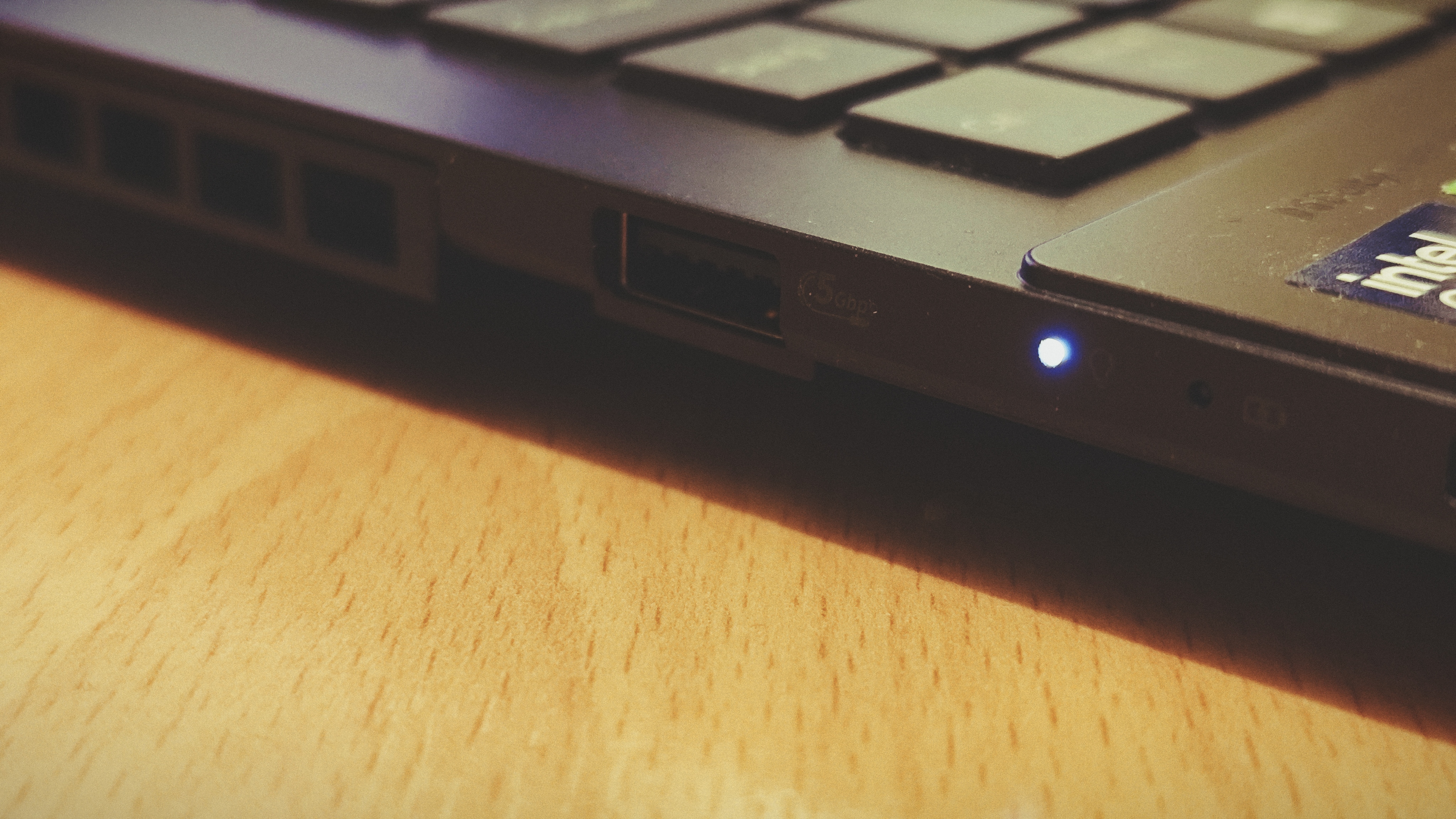 An Early Grey ASUS Vivobook Pro 15 OLED (2024) sitting on a wooden floor