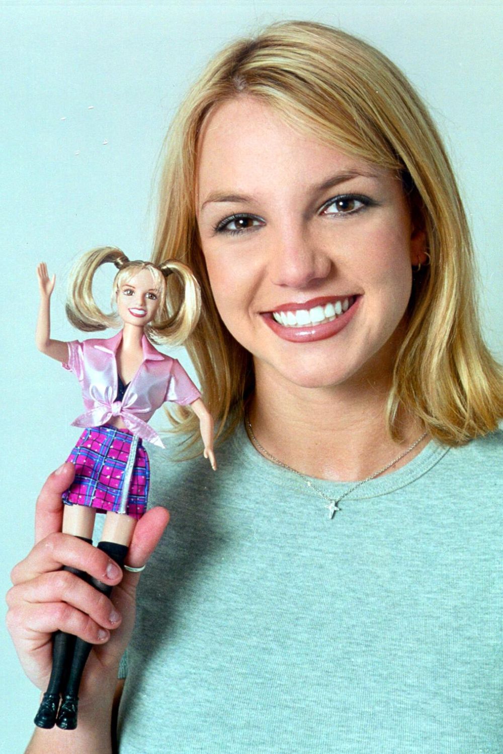 Britney Spears holds a doll of herself in the schoolgirl outfit from "...Baby One More Time"