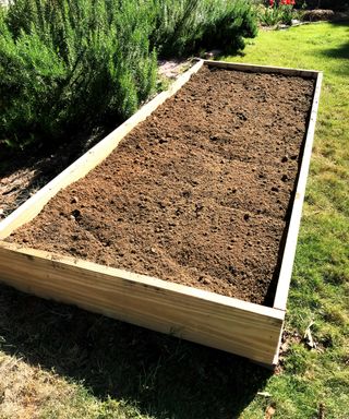 A raised garden bed filled with soil and compost