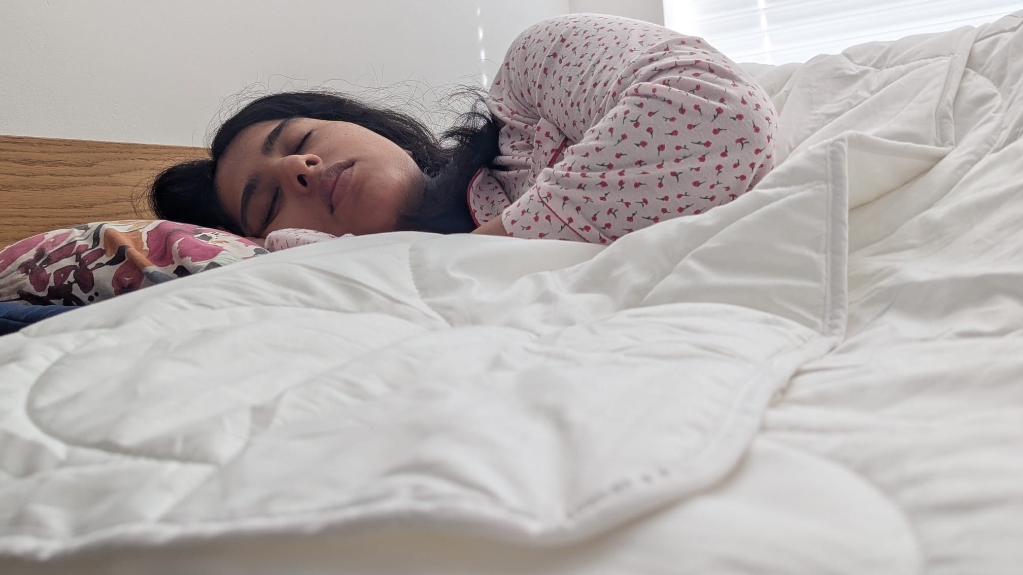 Woman sleeping in bed with the Larke Nature's Blend duvet draped over