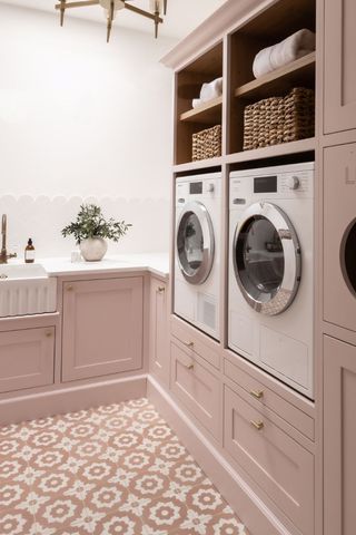 pink laundry room with washing machine and dryer
