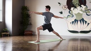 Man doing holding the warrior yoga pose