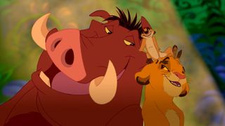 Timon, Pumba and a young Simba smiling during the Disney movie The Lion King.