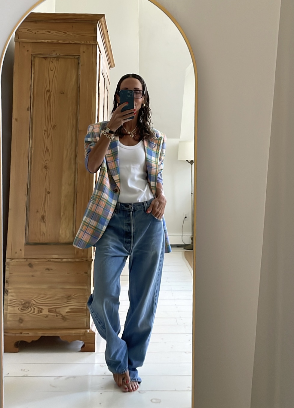 Larissa Mills wearing a white tank top and blue jeans outfit