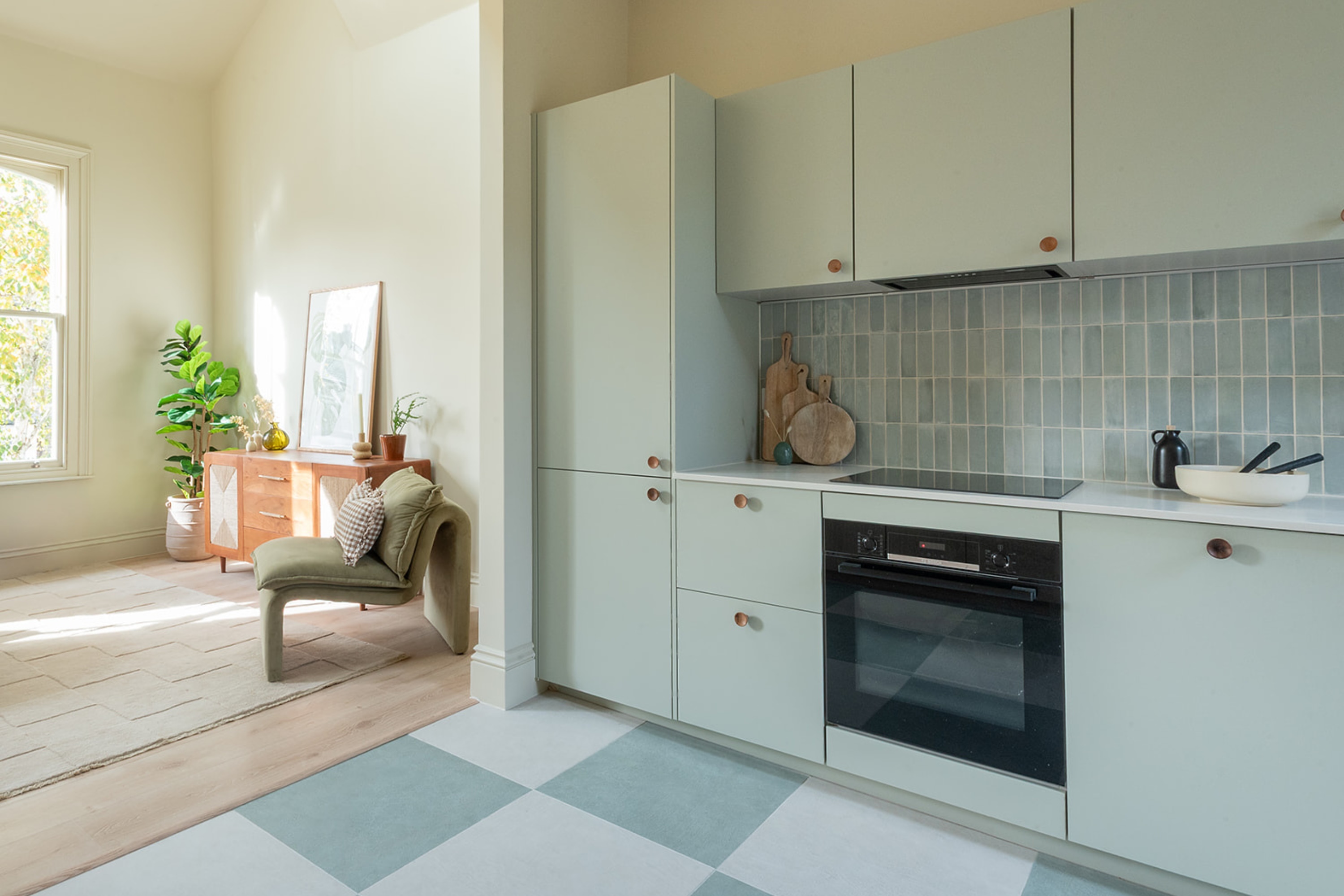 Sage green tonal kitchen with checkerboard floor