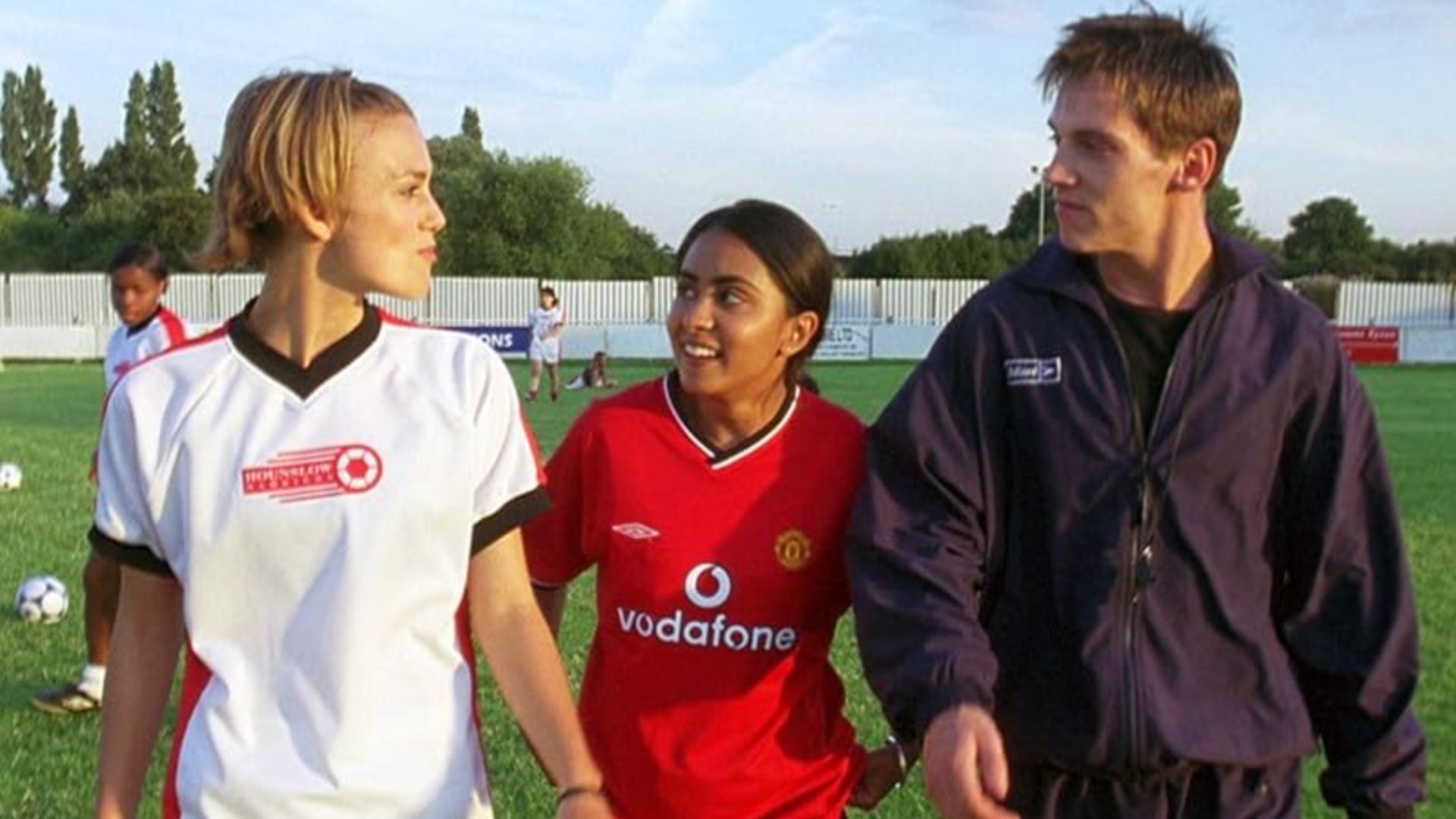 an image of kiera knightly, parminder nagra, and jonathan rhys meyers in character in bend it like beckham 