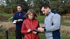 golfers marking scorecards on the tee