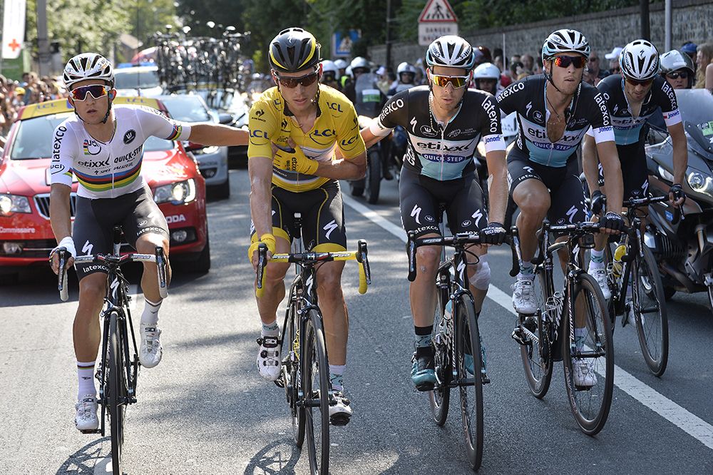 Etixx-Quickstep's Tony Martin is helped to the finish