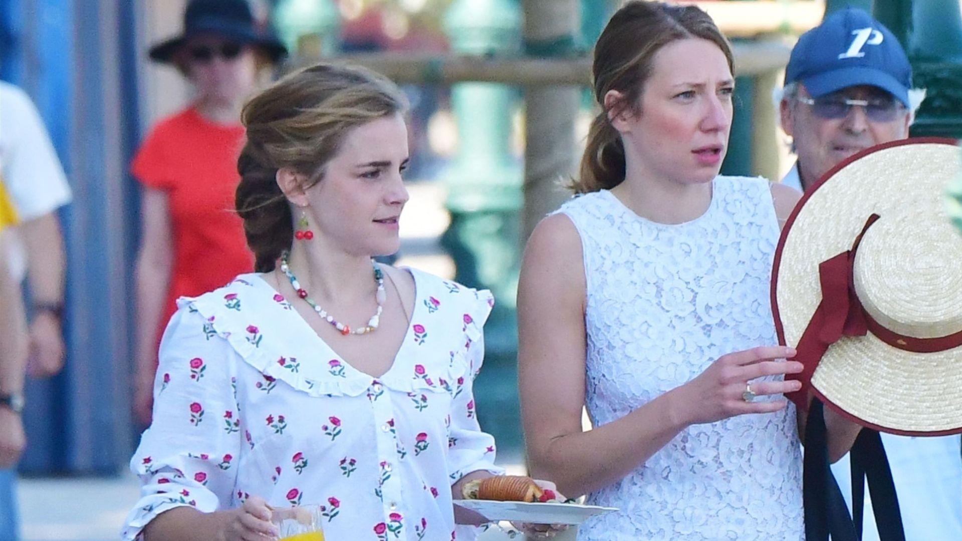 Emma Watson wears woven loafers with a matching floral cotton set. She's holding and orange juice and a plate with a croissant.