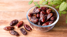 Bowl of dates on a wooden table 
