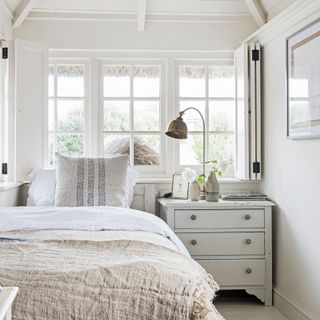 neutral bedroom with bedside cabinet and large window