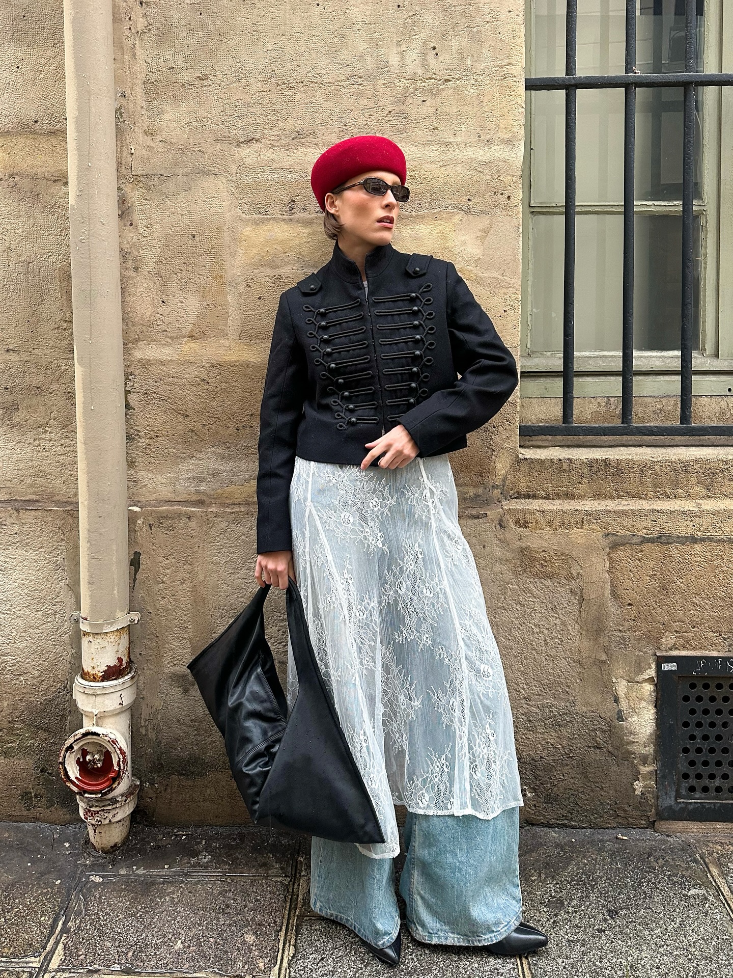 Girl posing for photo wearing jeans, red pillbox hat, Napoleon jacket and lace skirt
