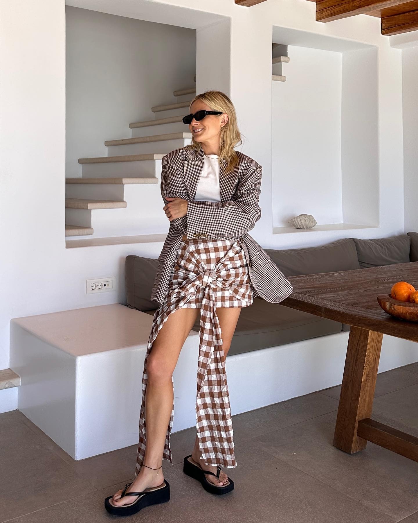 Fashionable character Lucy Williams wore a Gingham mini skirt with frontline details with a tie that landed on her left leg and right. She paired the skirt with 90-style platform slippers and a white T-shirt and checked out the blazer. She also wore Val sunglasses. The image was recently taken on her Instagram