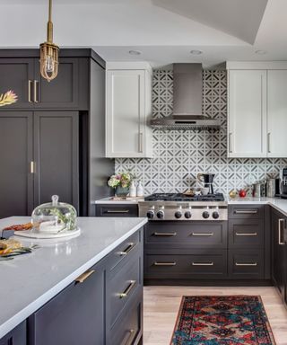 Charcoal black kitchen, blonde wood floor, vintage rug, lattice marble backsplash, marble effect countertops, white wall cabinets, white ceiling,