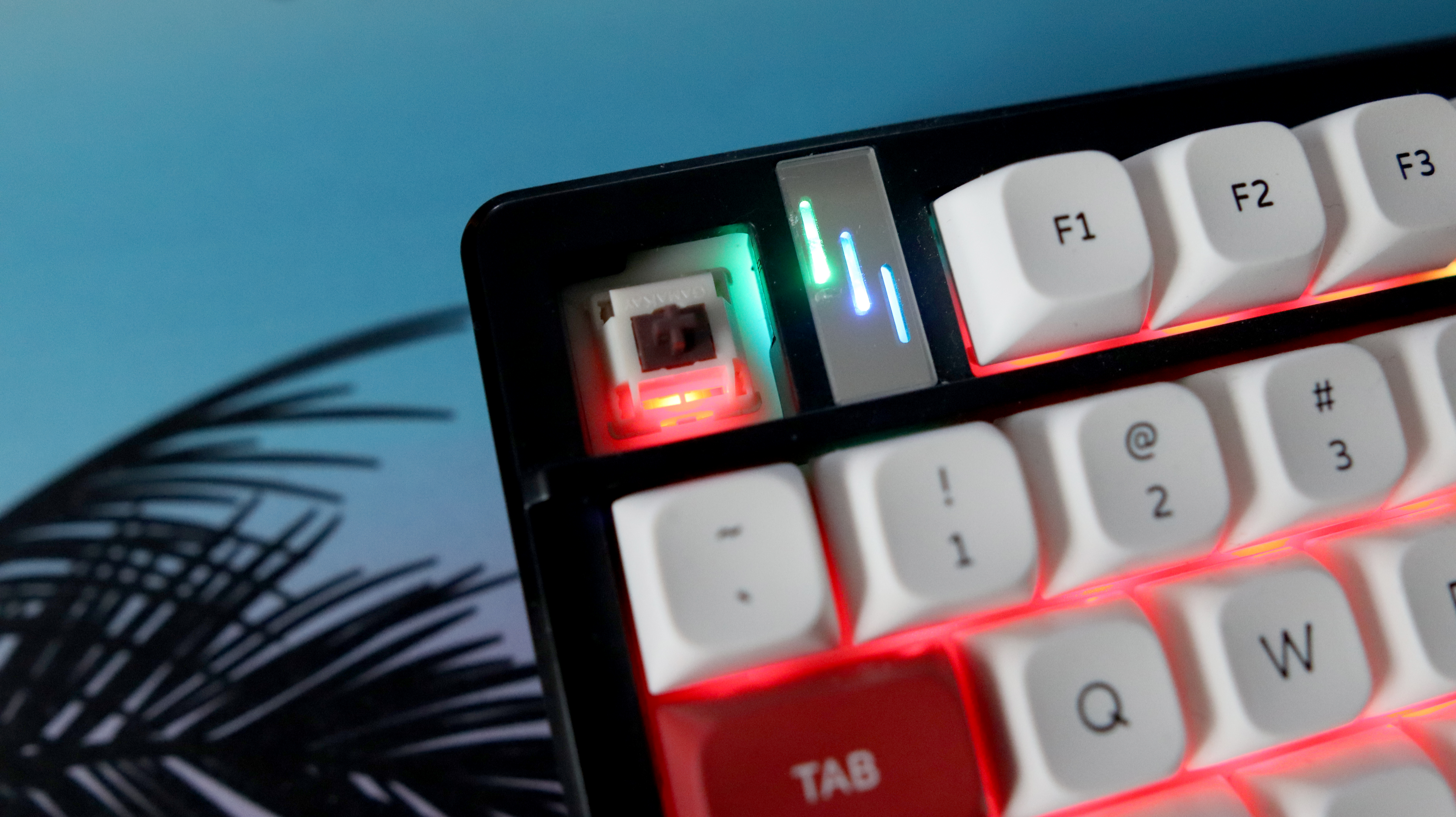 The Gamakay TK101 gaming keyboard in a red and white colourway and on a colourful mouse pad.