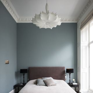 bedroom with white flower shaped ceiling lamp and bed