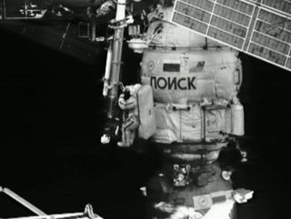 Russian cosmonaut Yuri Malenchenko works on a crane outside the International Space Station's Poisk module during a spacewalk outside the International Space Station on Aug. 20, 2012.