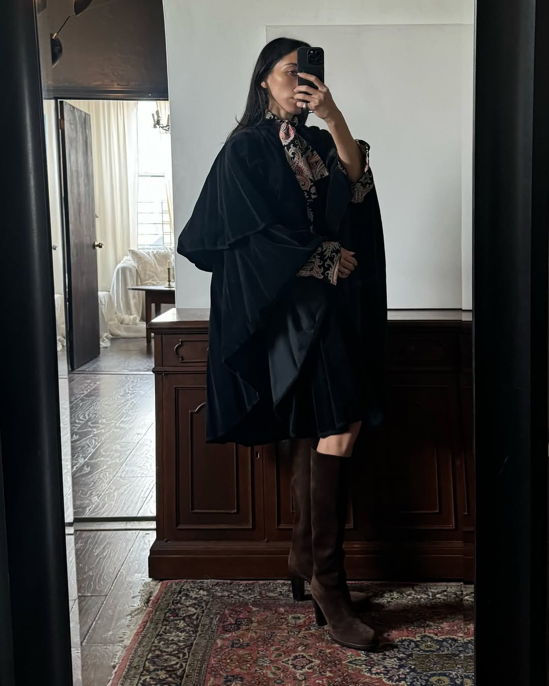 Alexis Badiyi wearing a velvet poncho with knkee-high boots