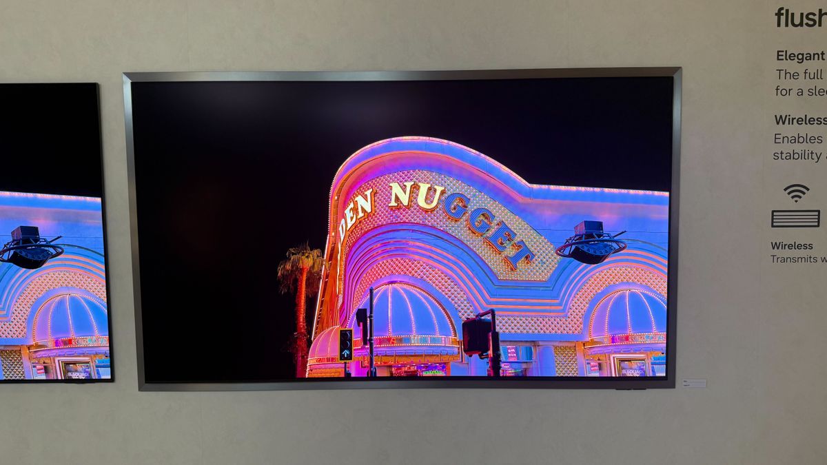 A wall mounted Samsung S95H showing stock footage of Las Vegas at night time