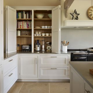 Open kitchen shelving next to range cooker