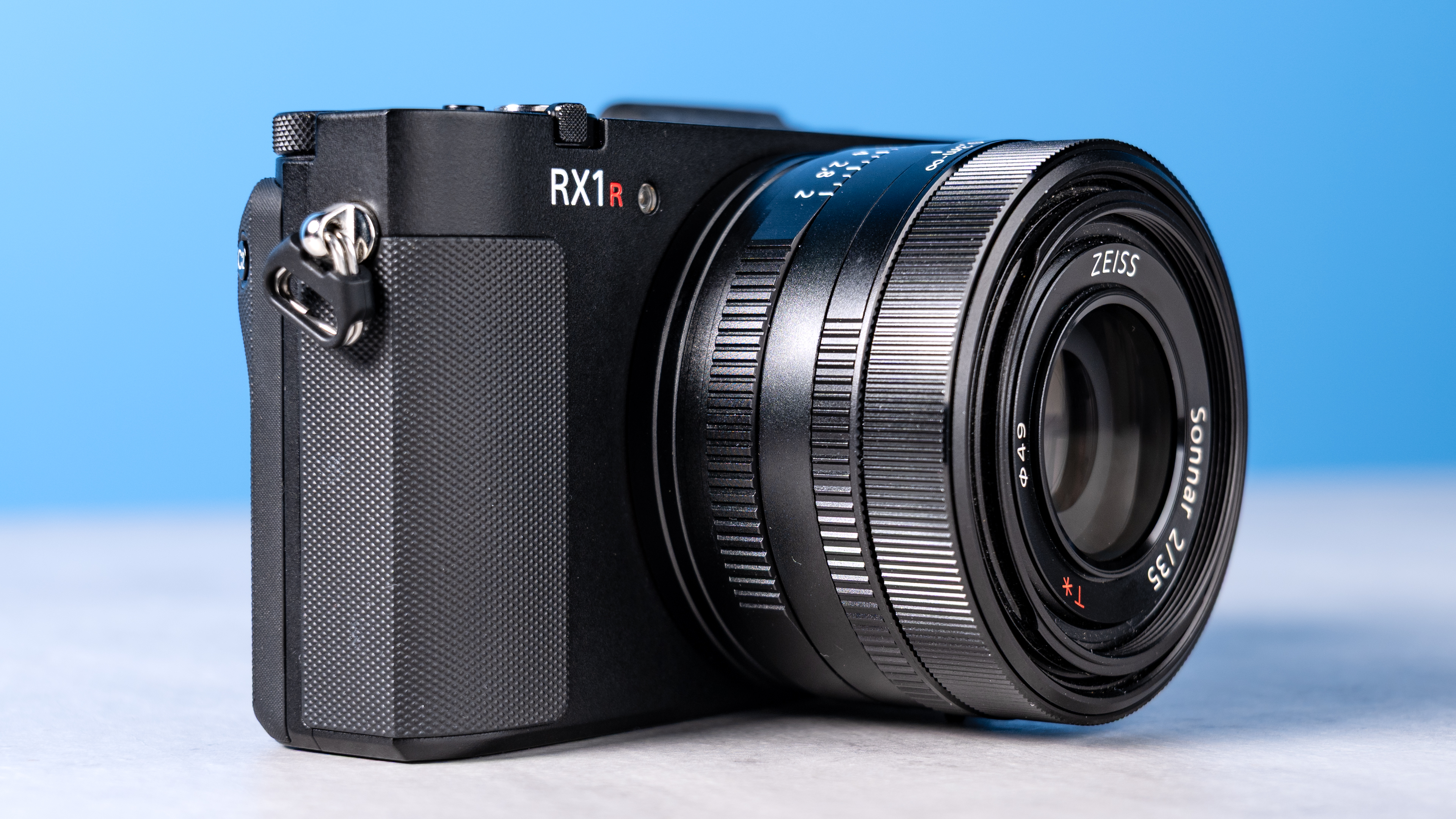 A photo of the Sony RX1R III on a stone surface with a blue background