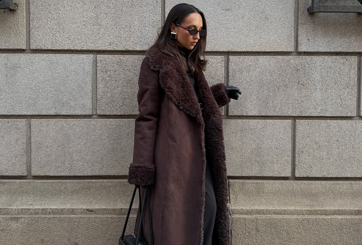 Ingrid wears a brown fur coat, black leather gloves, and black leather bag.