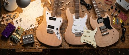 A work bench with a collection of DIY guitar kits