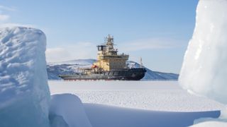 A winter landscape with an icebreaker amidst the ice. A view of the icebreaker in a frozen bay. Ice floes in the foreground.