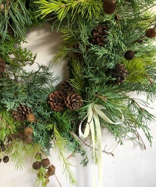 Close-up of pine cone Christmas wreath with cream ribbon bow