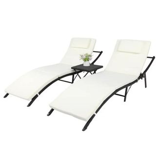 Two white foldable lounge chairs with metal legs and a small black table