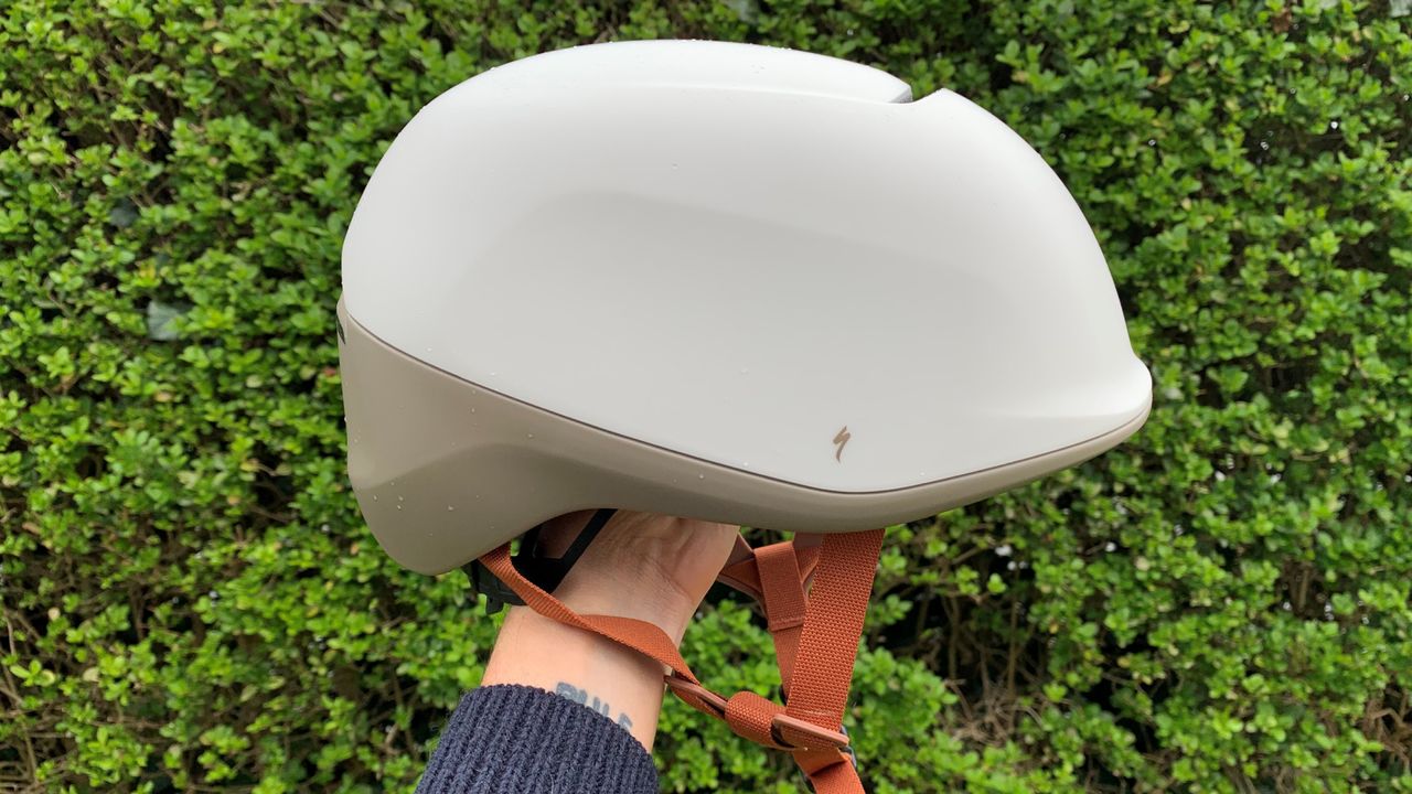 Male cyclist holding the Specialized Tone MIPS helmet