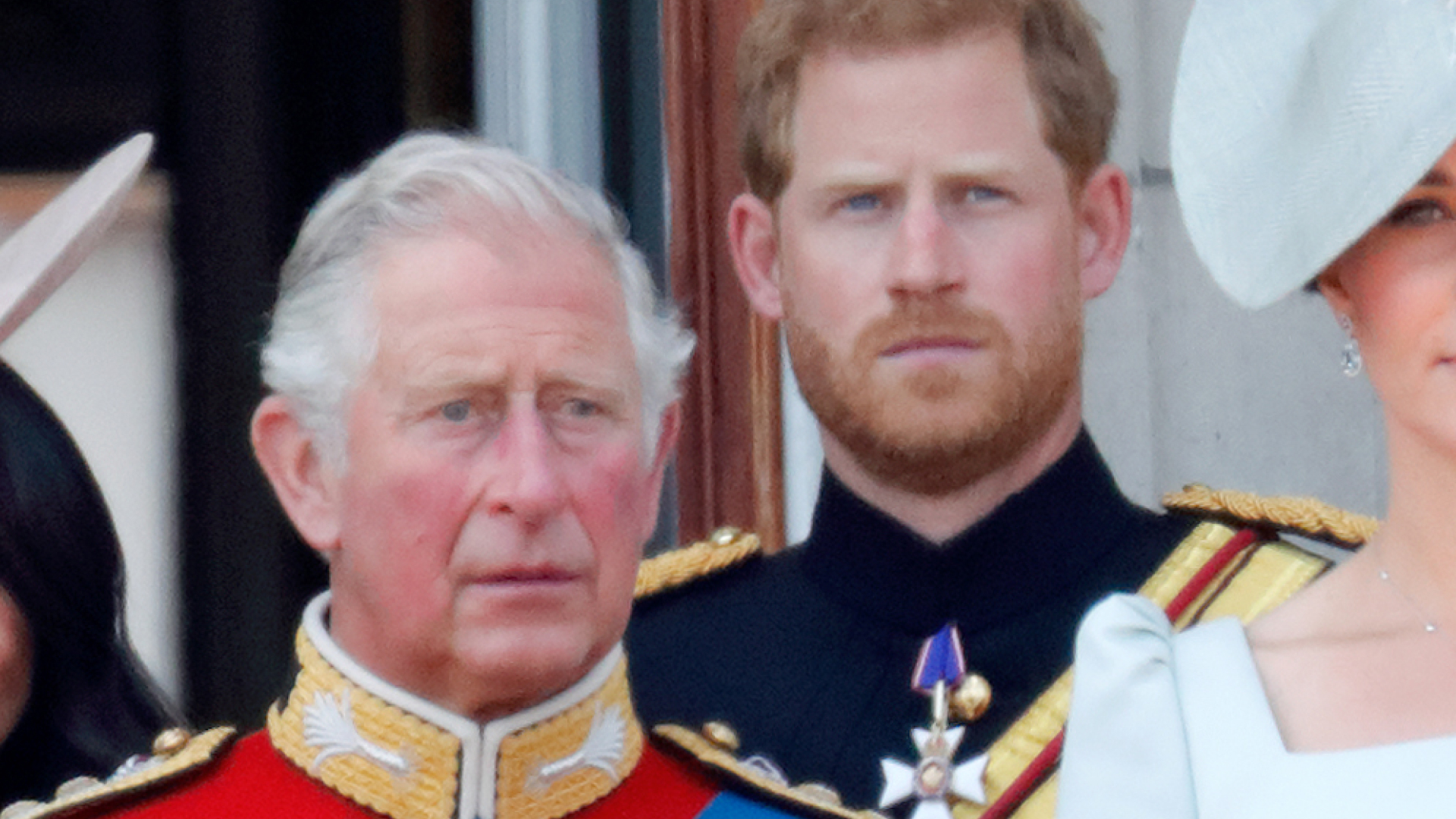 King Charles wears bright red military uniform and stands on the Buckingham Palace balcony with son Prince Harry